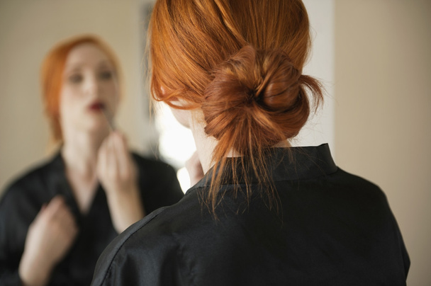 young woman applying make up - Фото, изображение