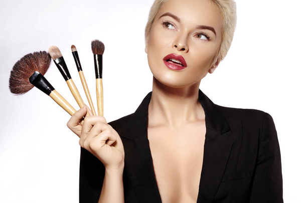 Beauty Treatment. Girl with Makeup Brushes. Fashion Make-up for Sexy Woman. Makeover. Make-up Artist Applying Visage on white background - Φωτογραφία, εικόνα