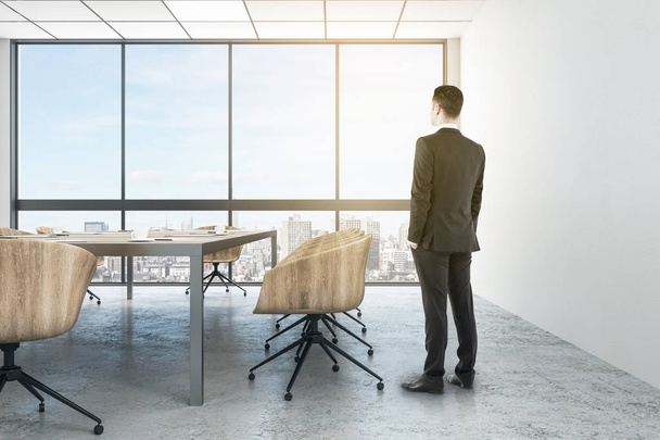 Attractive young european businessman standing in modern conference room interior with city view. Worker and executive concept. 3D Rendering  - Foto, Imagen