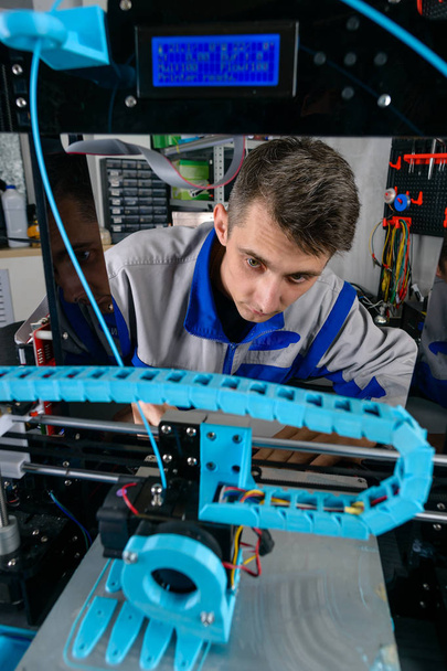 Nuori suunnittelija-insinööri, joka käyttää 3D-tulostinta laboratorio-, teknologia- ja innovaatiokonseptissa
 - Valokuva, kuva
