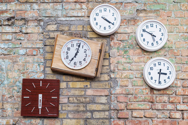 Круглые и квадратные белые часы висят на кирпичной стене
 - Фото, изображение