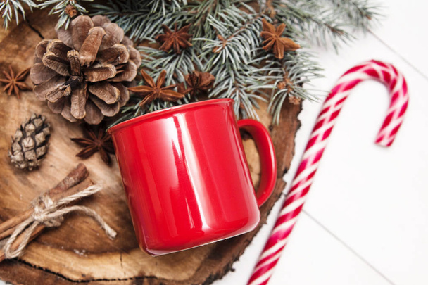 Красная чашка на деревянном стенде с рождественским декором
. - Фото, изображение