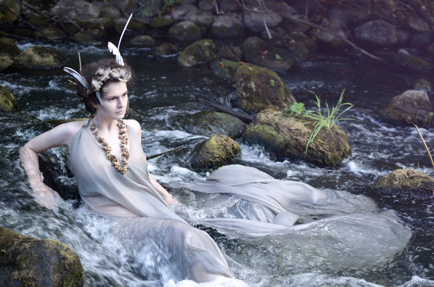 river nymph in a gray silk dress, a necklace of sea snail shells and a headdress of perevsidit and resting in his river - Photo, Image