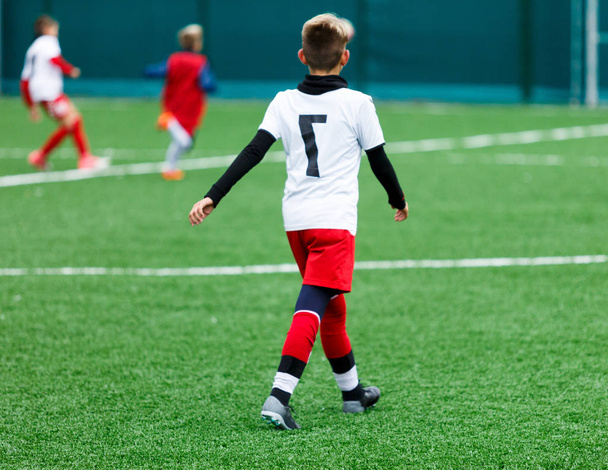 футбольні команди хлопчики в червоній, синій, білій формі грають у футбол на зеленому полі. хлопчики дриблінг. навички дриблінгу. Командна гра, тренування, активний спосіб життя, хобі, спорт для дітей концепція
 - Фото, зображення