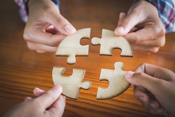 Hands of diverse people assembling jigsaw puzzle, Youth team put pieces together searching for right match, help support in teamwork to find common solution concept, top close up view - Photo, Image