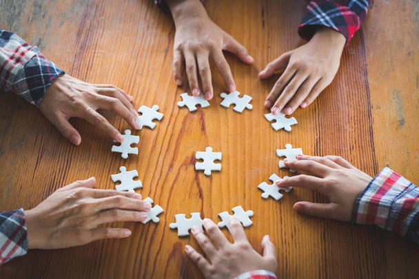 Mains de diverses personnes assembler puzzle puzzle, l'équipe de la jeunesse mis en pièces à la recherche d'un bon match, aider à soutenir dans le travail d'équipe pour trouver un concept de solution commune, top vue de près
 - Photo, image