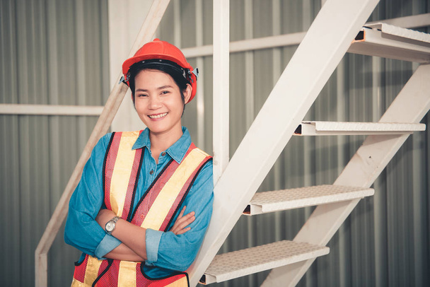 Portrait of an engineer woman posing crossed arms confident and happy with natural smile laughing. - Photo, Image
