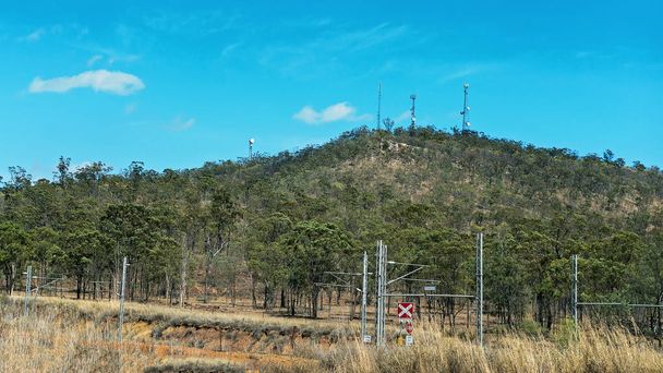 Infra-estrutura ferroviária em linhas eléctricas para o transporte de carvão das minas para o porto com torres de comunicação nas colinas
 - Foto, Imagem