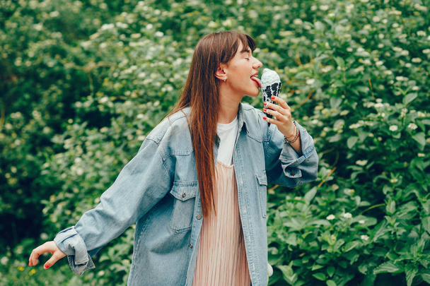 Girl walking in the park and eating ice cream - Фото, зображення