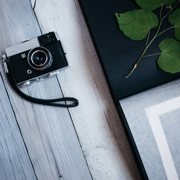 vintage camera, an old photo album on the white wooden background - Fotó, kép