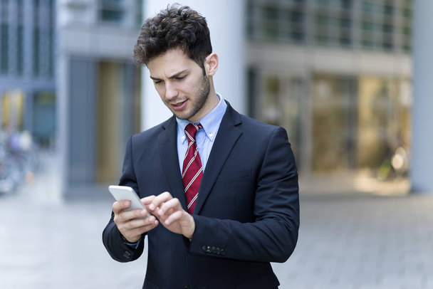 Portrait of a businessman using his mobile phone - Foto, afbeelding