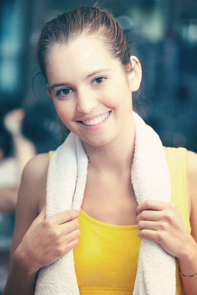 Portrait of young woman smiling in fitness club - Фото, зображення