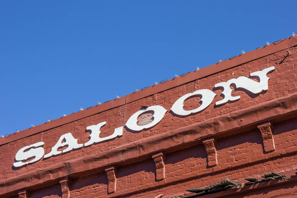 Vintage saloon letters on a red brick building in Nevada City, California - Photo, Image