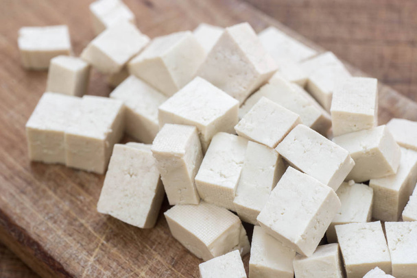 fresh tofu cubes on wooden cutting board macro - Fotó, kép