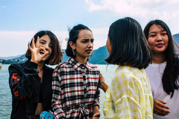 Pokhara Nepal October 6, 2018 Portrait of teens having fun and taking photos front the Phewa lake in Pokhara in the afternoon - Foto, immagini