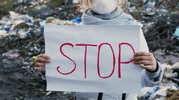 Girl activist with Stop poster on waste dump - Footage, Video