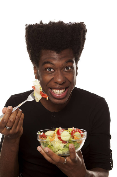 Hezký Afro americký mladík jíst salát izolovaných na bílém pozadí. zdravé jídlo koncept - Fotografie, Obrázek