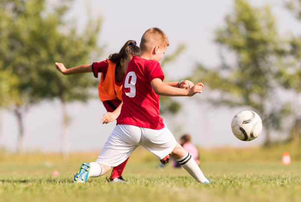 Pienet lapset pelaajat jalkapallo-ottelukentällä
 - Valokuva, kuva