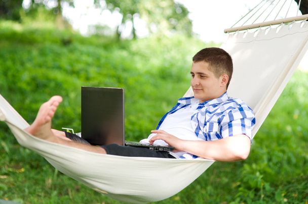 Lavorando sul hammock con il computer portatile
 - Foto, immagini