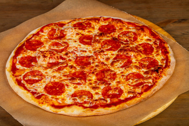 Pizza-Peperoni mit Würstchen über hölzernen Speck - Foto, Bild