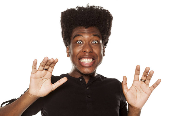 Portrait of a young shocked African american modern man on a white background - Photo, Image