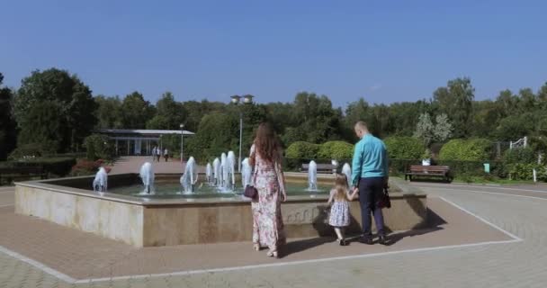 Young family in the park with a fountain - Filmagem, Vídeo