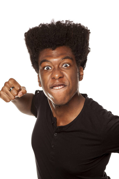 Portret van een jonge agressieve African american man op een witte achtergrond - Foto, afbeelding