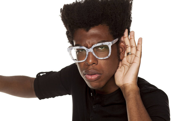 Portréja egy afro-amerikai modern fiatalember gondosan figyel egy fehér háttér - Fotó, kép