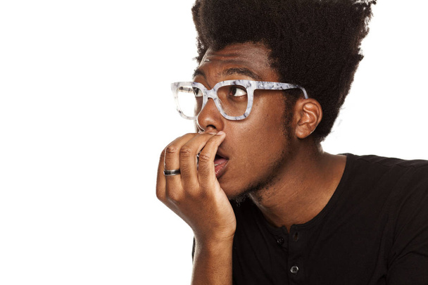 Portret van een jonge African american moderne man zijn adem op een witte achtergrond te controleren - Foto, afbeelding