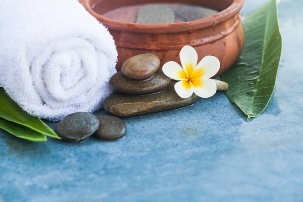 Flower, towel and stones for massage salon on blue marble background. - Photo, Image