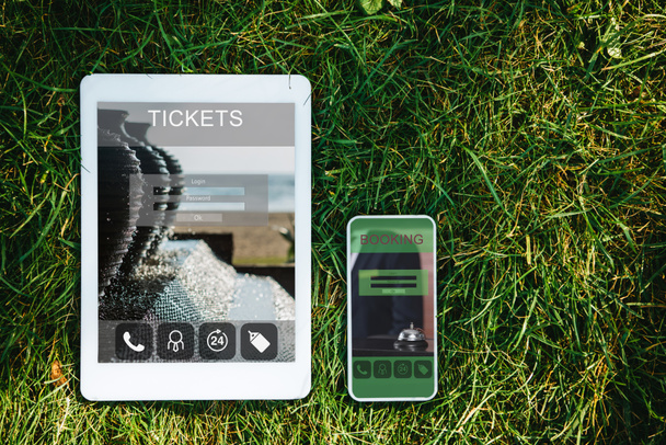 Κάτοψη των gadgets με τα εισιτήρια και κράτηση συσκευές για την πράσινη χλόη στο πάρκο - Φωτογραφία, εικόνα