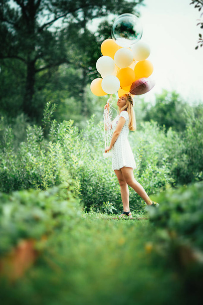 young girl with balloons on nature background. - Foto, immagini