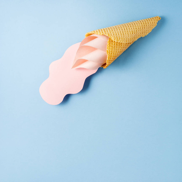 Creative concept photo of ice cream cone and splash made of paper on blue background. - Фото, зображення