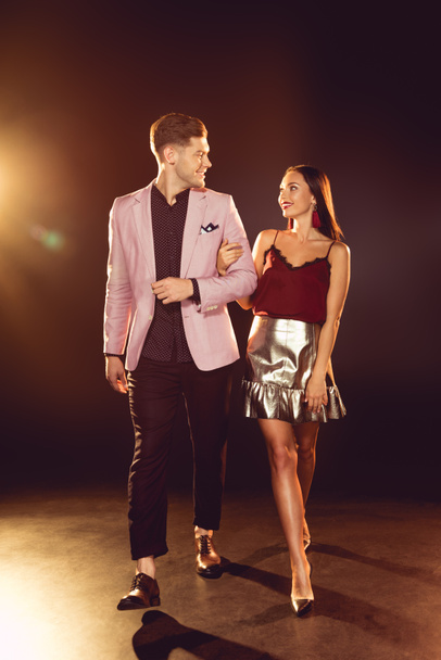 luxury smiling couple walking arm-in-arm on night party with backlit  - Foto, Imagem