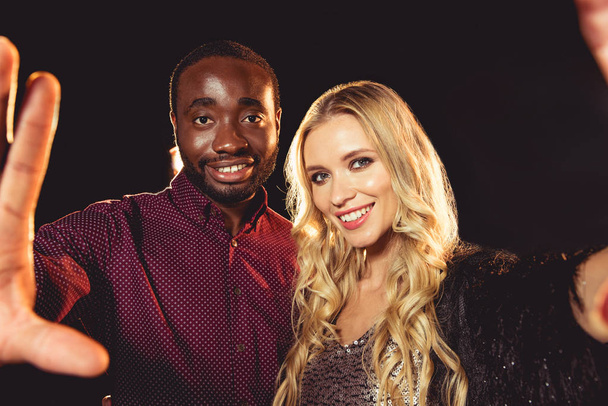 interracial couple taking selfie on new year party with backlit  - Zdjęcie, obraz