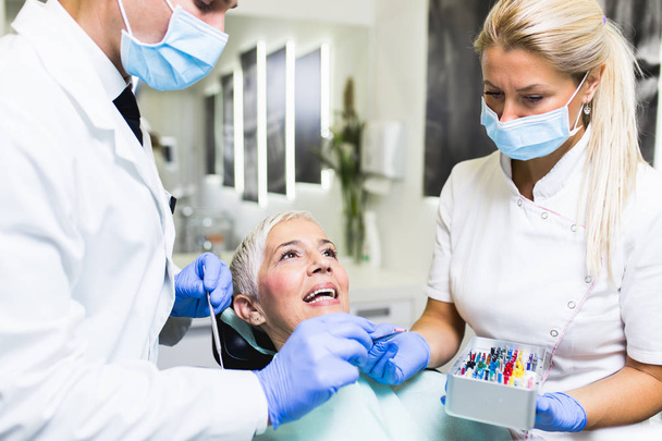 Gyönyörű idős nő, fogászati kezelés a fogorvosi rendelőben.   - Fotó, kép