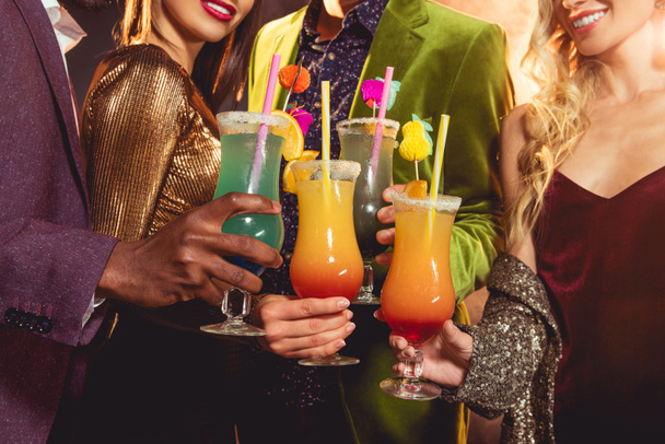 vista recortada de amigos sosteniendo cócteles de alcohol en la fiesta
 - Foto, Imagen