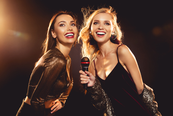 attractive cheerful women singing with microphone in karaoke - 写真・画像