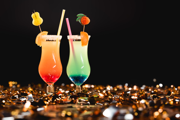 Süße Cocktails mit Strohhalmen auf goldenem Konfetti mit Kopierraum - Foto, Bild