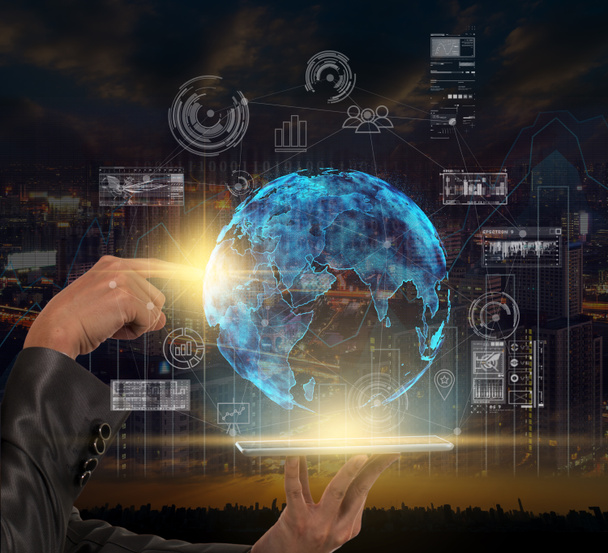 Hand holding the lablet and pointing the particle of earth over technology icon and business graph over Trading graph on the cityscape, innovation concept - Photo, Image