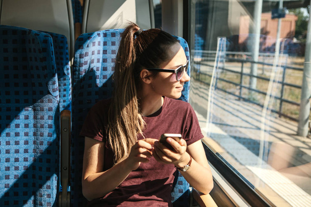 Турист в поезде пользуется мобильным телефоном
. - Фото, изображение