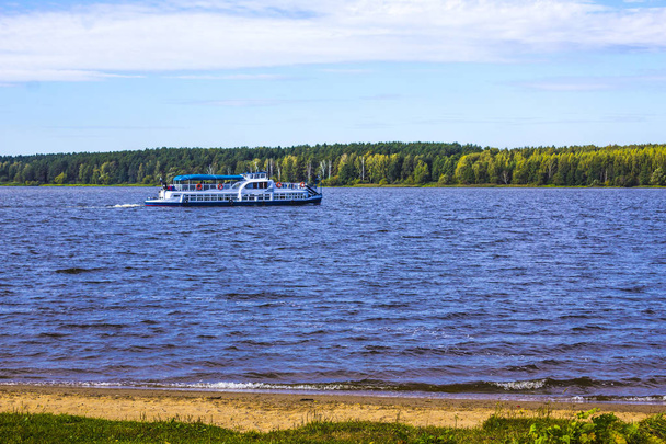 Sunny day. The Volga River near Konakovo. Pleasure boat in the middle of the river.Tver Region,Russia.Background for the site about travel, vacation.  - Foto, Imagen
