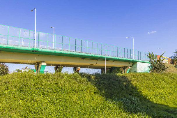 Sound absorbing screens on the highway and overpass and green grass on the slope.Metal frames filled with glass. Modern technology in Warsaw,Poland. - Photo, Image