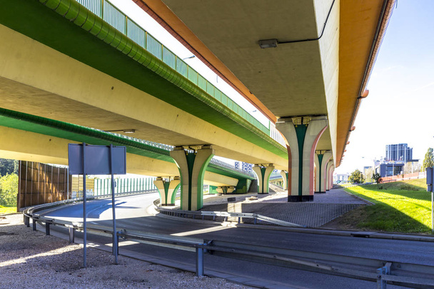 Highway, viaducten en gekleurde betonnen kolommen. Geluid absorberende schermen zijn metalen frames gevuld met glas. Moderne technologie in Warschau, Polen. - Foto, afbeelding