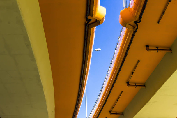 高速道路や色付きのコンクリート歩道橋。青い空とのギャップで金属ランタン。ワルシャワ, ポーランドの現代技術. - 写真・画像
