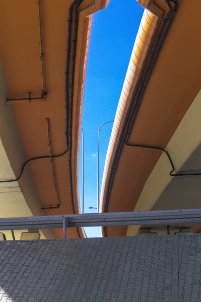 Snelweg en beton viaducten. Sky en metalen lantaarn in de kloof. Betonnen tegel versterkt de helling van de heuvel. Moderne technologie in Warschau, Polen. - Foto, afbeelding