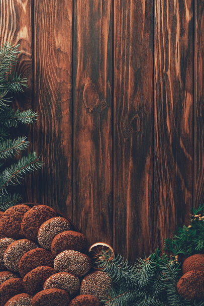 top view of tasty baked cookies and fir twigs on wooden table, christmas concept - Zdjęcie, obraz