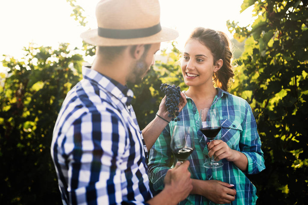 Couple in love working at winemaker vineyard and tasting wines - Foto, Imagen