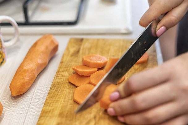Cortar zanahorias en la cocina del hogar al preparar alimentos enlatados para el invierno
 - Foto, imagen