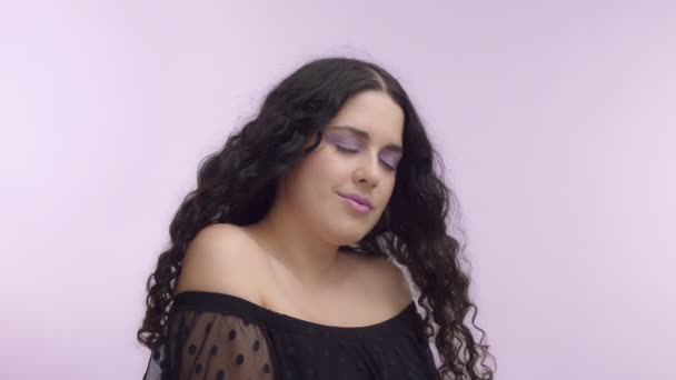 black curly hair plus size model with brown eyes on lilac background with lilac makeup - Metraje, vídeo